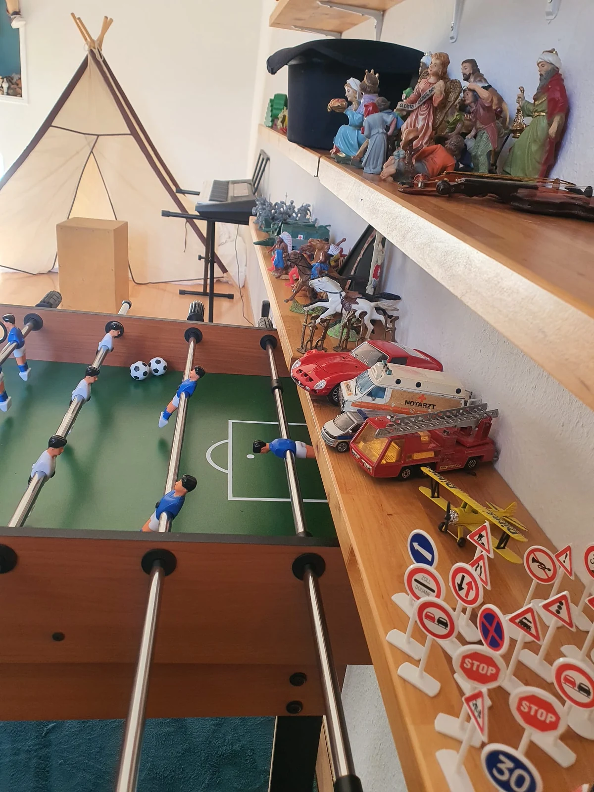 Espace de jeu avec baby-foot, véhicules miniatures, figurines et tente de jeu