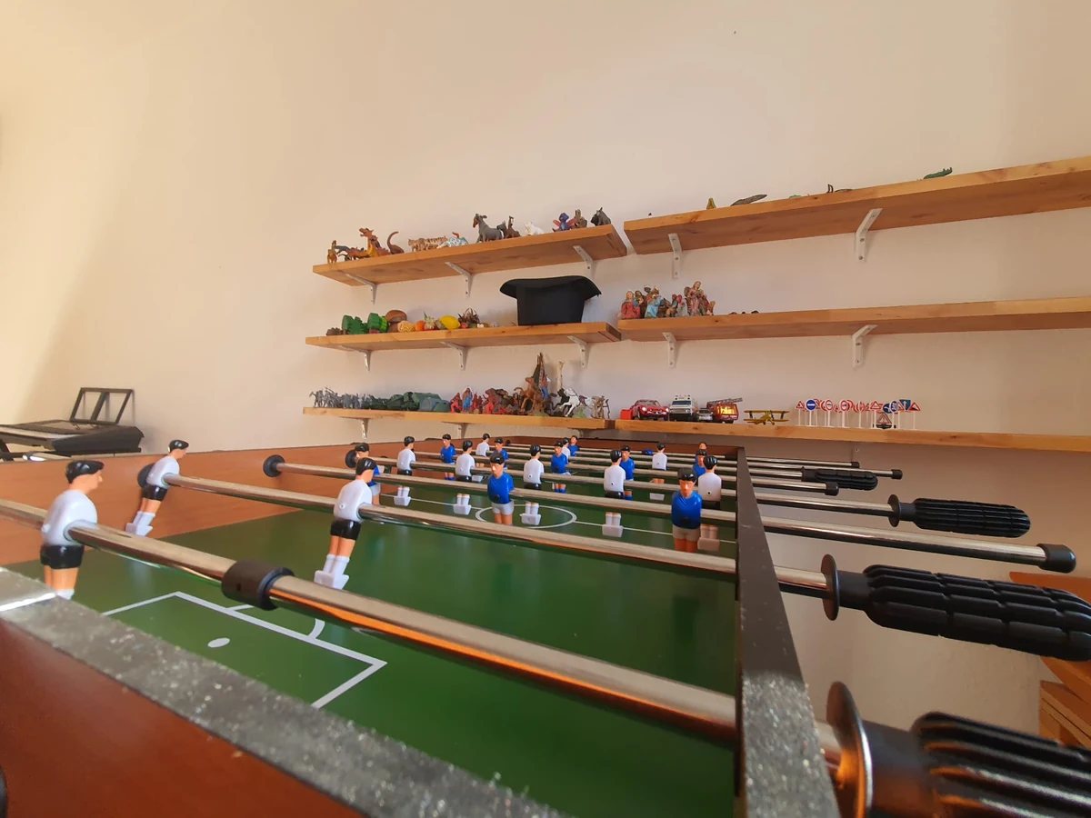 Baby-foot et figurines sur des étagères en bois du cabinet